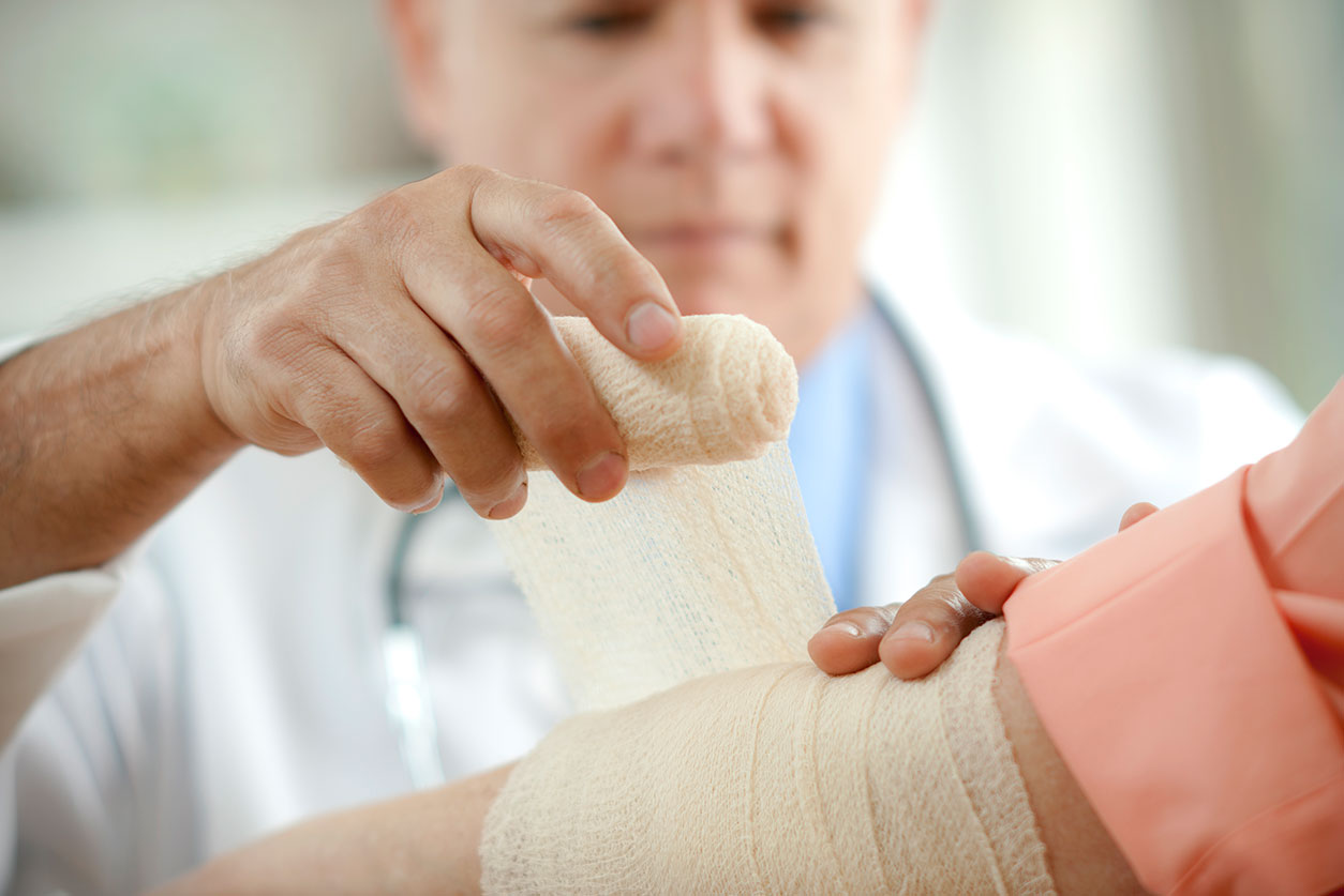 Doctor wrapping bandage around arm