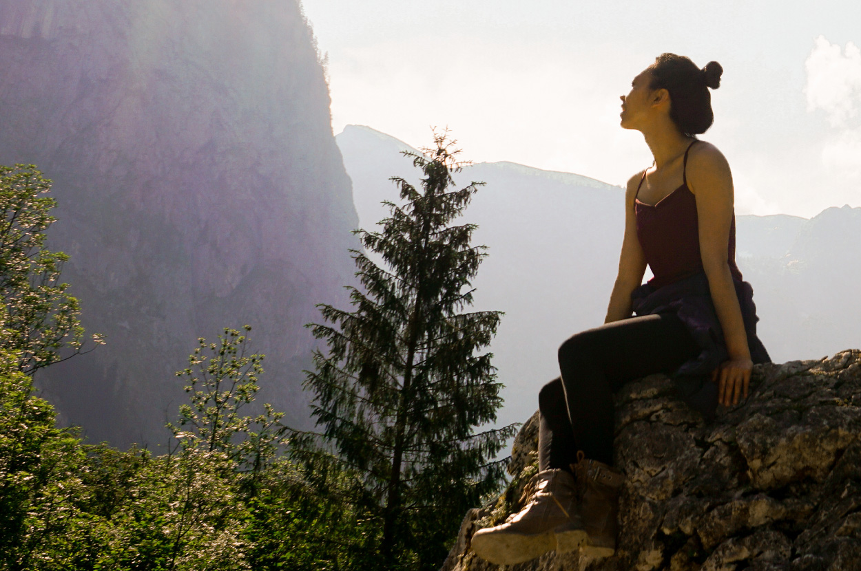 Woman sitting on the rock looking at the mountains